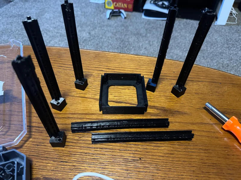 Black printed frame rails and mounting components laid out before assembly.